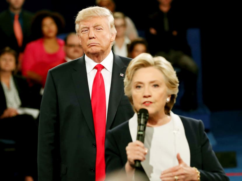 Republican U.S. presidential nominee Donald Trump listens as Democratic nominee Hillary Clinton answers a question from the audience during their presidential town hall debate at Washington University in St. Louis, Missouri. Photo: Reuters