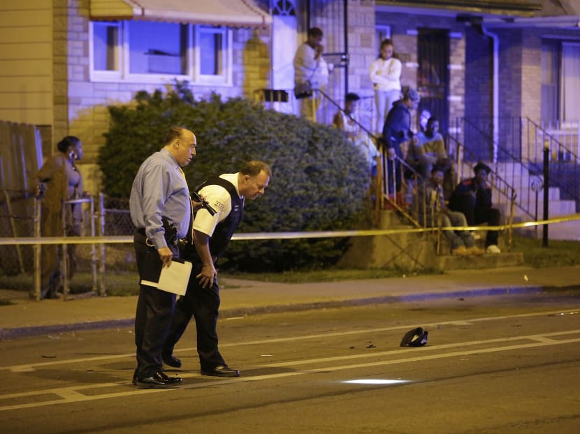 A Chicago Police officer and a detective investigate a shooting in Chicago, May 24, 2015. Photo: The New York Times