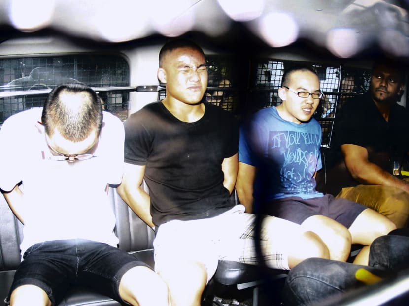Three of the five suspects seen being brought to court on May 10, 2014 to be charged for allegedly vandalising the rooftop of a HDB flat in Toa Payoh. Photo: Ernest Chua
