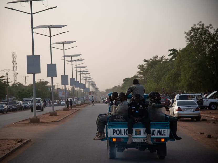 Police officers, supported by a team of municipal officers, drive on a pick up truck in Niger capital Niamey on April 23, 2020.