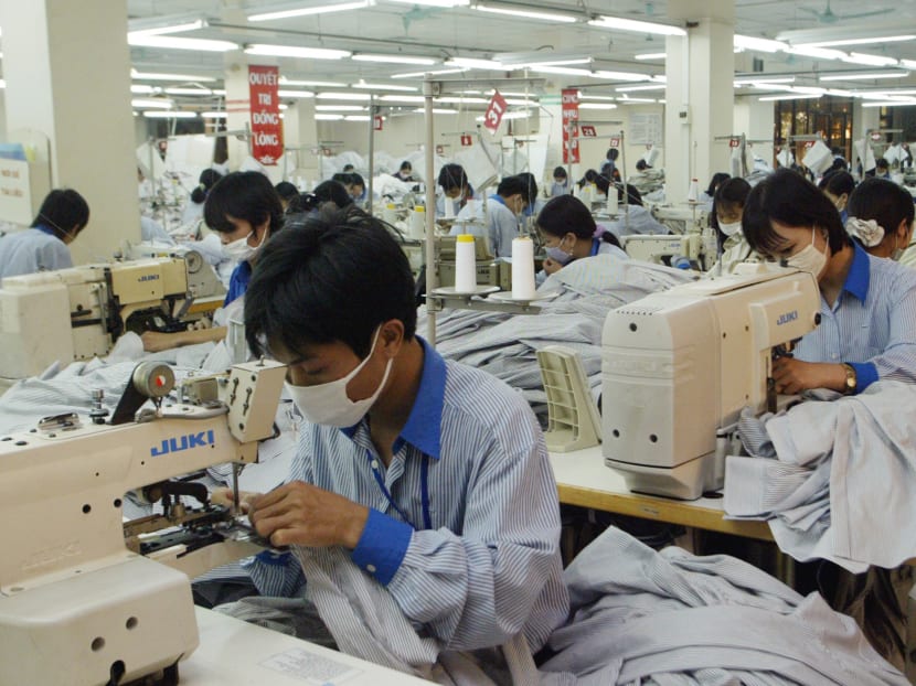 A file photo showing workers sewing shirts to be exported to the United States at Garment Company 10 outside Hanoi Vietnam. Photo: AP
