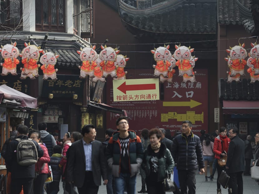 Visitors walk past Lunar New Year decoration on display at Yu Garden in Shanghai Tuesday, Feb. 17, 2015. Photo: AP