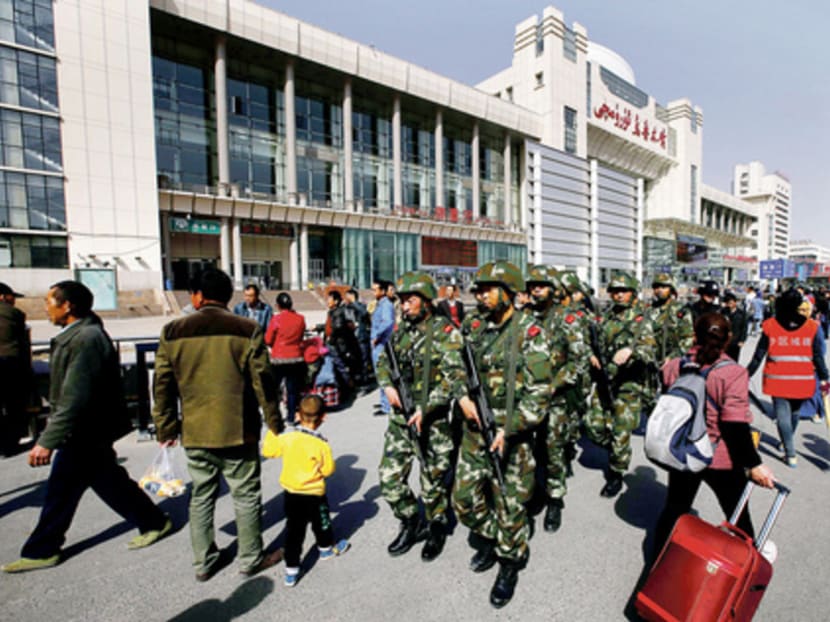 Armed policemen patrolling near the exit of a railway station in Urumqi where a deadly attack occurred in May. Beijing announced a one-year security clampdown in Xinjiang that month. Photo: Reuters