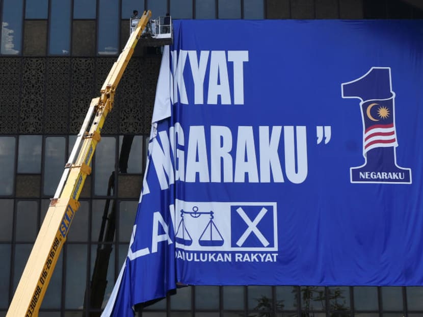 A worker tears down a Barisan Nasional flag at Putra World Trade Centre (PWTC) in Kuala Lumpur, Malaysia on May 10, 2018.