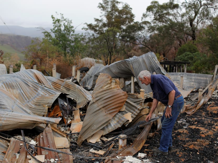 A man looks through the remains of his family home destroyed by bushfire in Buchan, Victoria, Australia, January 23, 2020.
