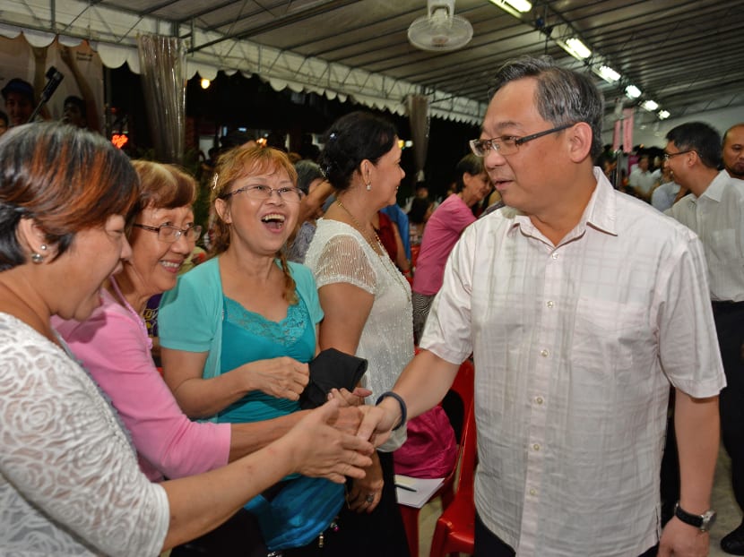 Minister of Health Mr Gam Kim Yong (right) greeting members of the public at the launch of the SG50 Seniors Package. Photo: Robin Choo