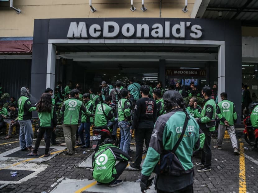 Food delivery riders make their way into a McDonald’s outlet in Bogor on June 9, 2021, to buy the new BTS-meal deal for hungry fans in the K-Pop mad country, causing more than a dozen McDonald's outlets to temporarily shuttered over virus fears.