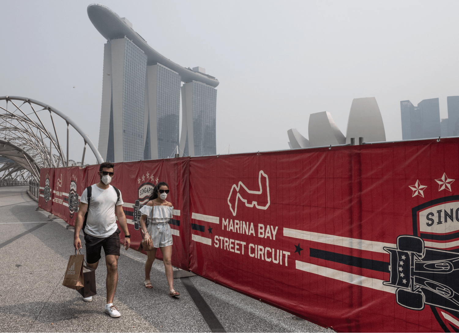 Tourists wearing protective masks as they walked near the Formula One race track while haze blanketed Singapore in September 2019. Tourists wearing protective masks as they walked near the Formula One race track while haze blanketed Singapore in September 2019.