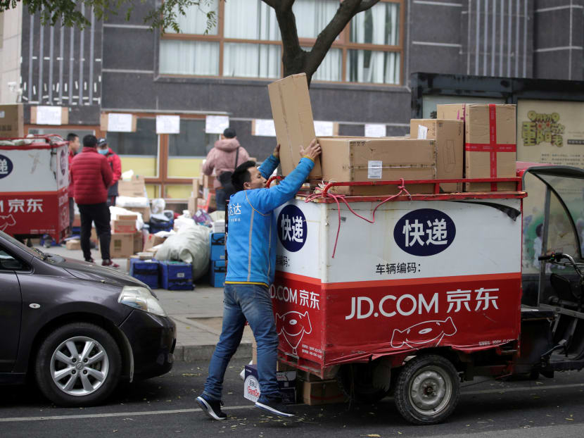 A deliveryman packs parcels on the top of a tricycle beside a road after the 11.11 Singles' Day shopping festival in Beijing, China, Nov 14, 2018.