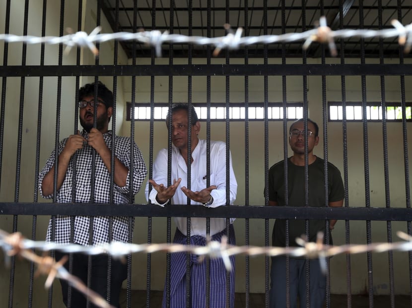 (From left:) Aung Naing Soe, a Myanmar freelance journalist and interpreter stands alongside driver Hla Tin and Singaporean Lau Hon Meng, a journalist for Turkish radio and television, at the court's temporary cell during their trial Friday. The trio have been accused of illegally flying drones over and around government parliament buildings. Photo: AP
