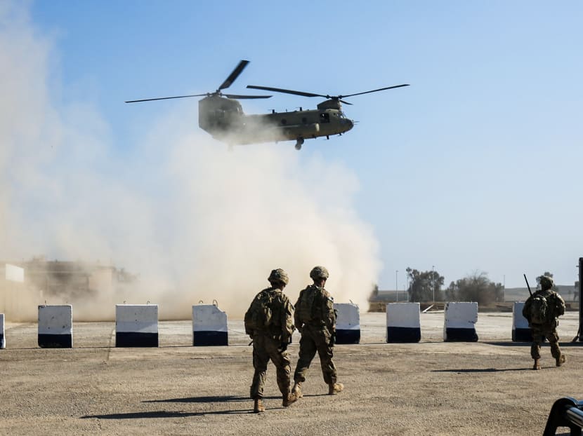 In this file photo taken on Feb 22, 2017 US troops walk as a US Army C-47 Chinook helicopter flies over the village of Oreij, south of Mosul. US president Donald Trump will announce further troop withdrawals from Iraq and Afghanistan in the next few days, a senior administration official said.