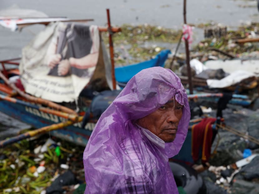 A fisherman stays next to his boat docked along the shore in Manila bay after Typhoon Sarika slammed central and northern Philippines, Oct 16, 2016.  Photo: Reuters