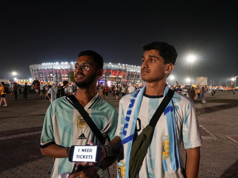 A man holds a smartphone with a sign that reads: "I need tickets" ahead of a Fifa World Cup Qatar 2022 match in Doha, Qatar on Nov 30, 2022. 

