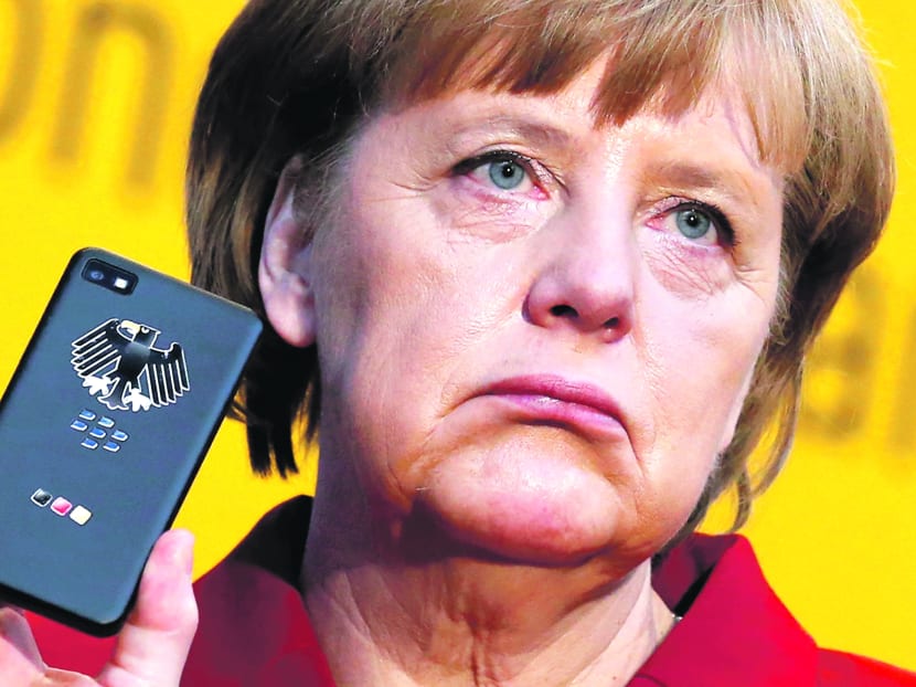 Ms Merkel holding a BlackBerry Z10 smartphone that features high security Secusite software, used for governmental communication, in March. Germany said on Wednesday it had evidence that Ms Merkel’s phone had been monitored. Photo: Reuters