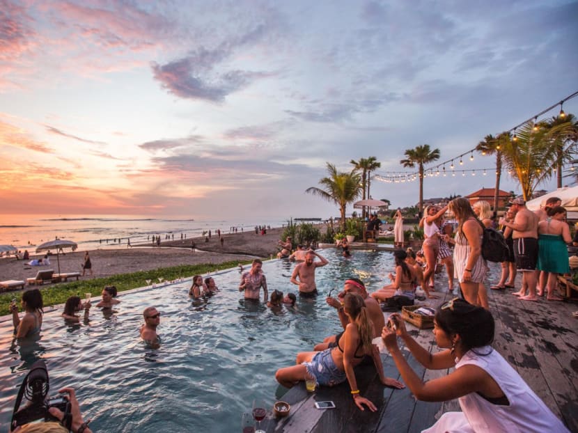 Tourists at The Lawn in Canggu, Bali in Indonesia. People are likely to act more hedonistically while on holiday, says the author. Tourists at The Lawn in Canggu, Bali in Indonesia. People are likely to act more hedonistically while on holiday, says the author.