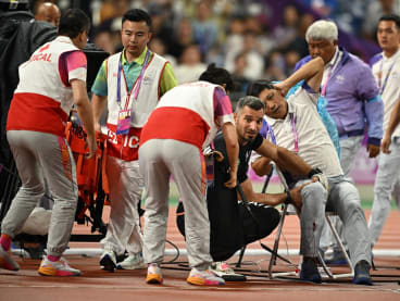 A judge is injured after Kuwait's Ali Zankawi throws the hammer through the net during the Men's Hammer Throw Final at the Hangzhou Asian Games on Sept 30, 2023.
