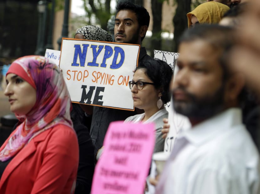 File photo of a group of people holding signs and protesting the New York Police Department’s program of infiltrating and informing on Muslim communities during a rally near police headquarters in New York. Photo: AP
