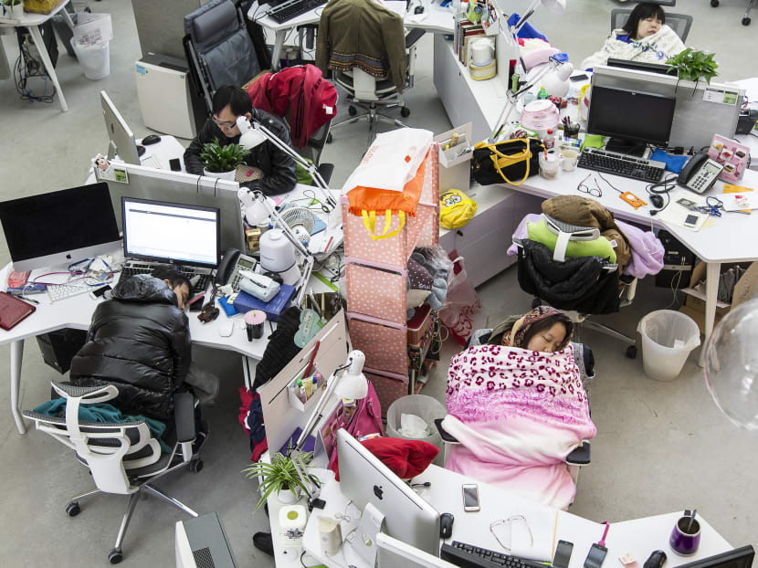 Employees take naps during lunch hour at Tencent in Guangzhou, China, Dec 24, 2013.