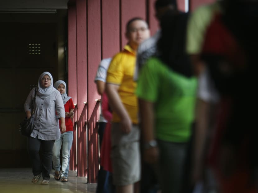Voters arrive to a polling station during the Malaysian general elections on May 5, 2013. A monsoon-season election in Malaysia could threaten turnout and hurt the credibility of the result, says a minister, signaling the vote is likely to now be held next year. Photo: Reuters