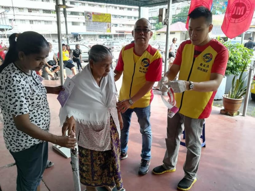 Clad in their distinctive yellow and red shirts, two members of the Malaysian United Party (MUP) help an elderly Penangite at a local community event. Several new parties have mushroomed in Penang since the 2013 general election and they are expected to throw their hats into a crowded contest as Malaysia heads towards a national poll that is expected to be called in the next few months. Photo: Facebook/Malaysian United Party