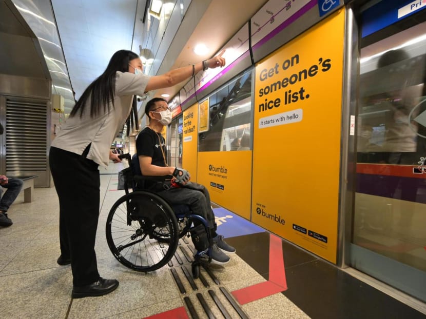 A photo showing an SBS Transit frontline staff providing assistance to a person with disability. A photo showing an SBS Transit frontline staff providing assistance to a person with disability.