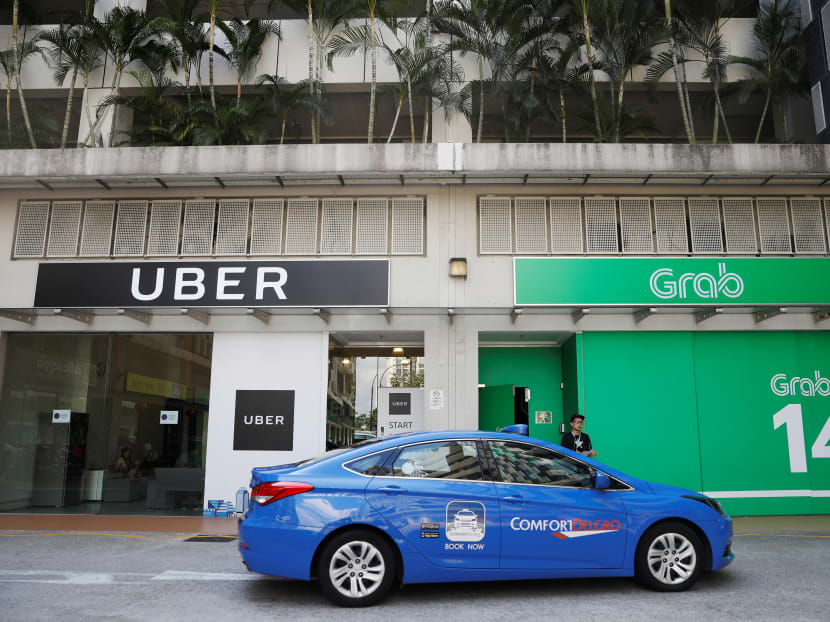 A ComfortDelgro taxi passes Uber and Grab offices in Singapore.