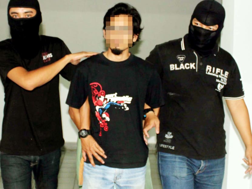 The suspected bomber (centre) confessed to planning to blow himself up in an attack after receiving orders from IS members. Photo: Royal Malaysia Police