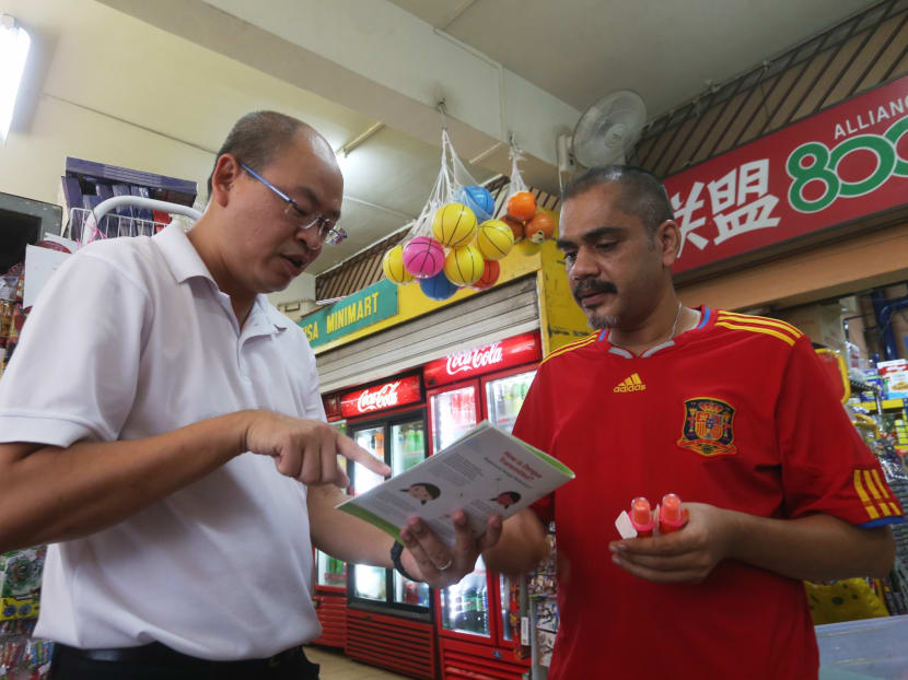 Member of Parliament for Chua Chu Kang GRC Yee Chia Hsing (photo left) handing out an educational pamphlet on dengue and insect repellent to Jurong West resident Noorul Zunaid during house visits to the neighbourhood on Sunday (May 6).