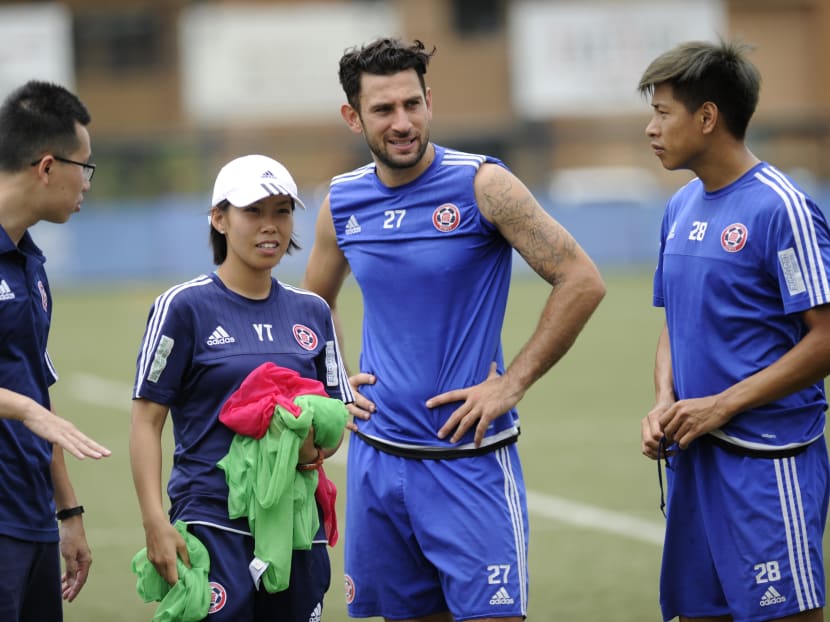 This picture taken on May 11, 2016 shows head coach of Eastern Football club Chan Yuen-ting (2nd L) talking to her players during a team training session in Hong Kong. Hong Kong trailblazer Chan Yuen-ting became the first woman coach to take a men's football team to a top-flight title thanks to the toughness that earned her the nickname "beefball" and a teenage crush on David Beckham. Photo: AFP
