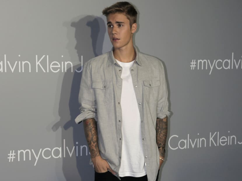 Canadian singer Justin Bieber poses for photographers upon his arrival at a promotional event for Calvin Klein in Hong Kong. Photo: AP