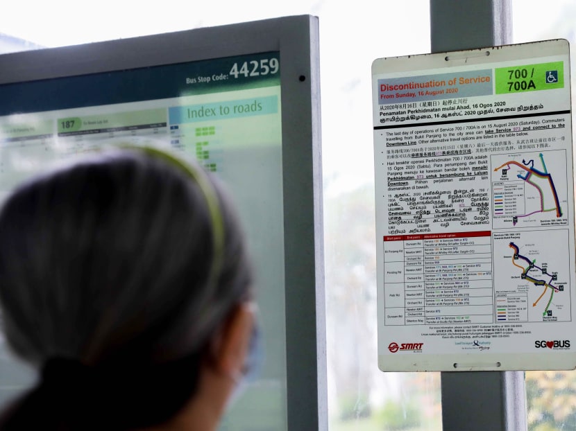 A commuter looking at a poster detailing the discontinuation of SMRT bus services 700 and 700A. A commuter looking at a poster detailing the discontinuation of SMRT bus services 700 and 700A.