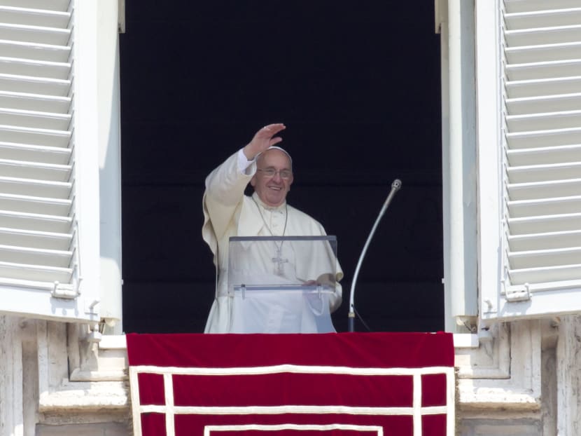 Pope Francis waves to the faithful as he arrives to recite the Angelus noon prayer from his studio window overlooking St. Peter's Square at the Vatican, Aug 9, 2015. Photo: AP