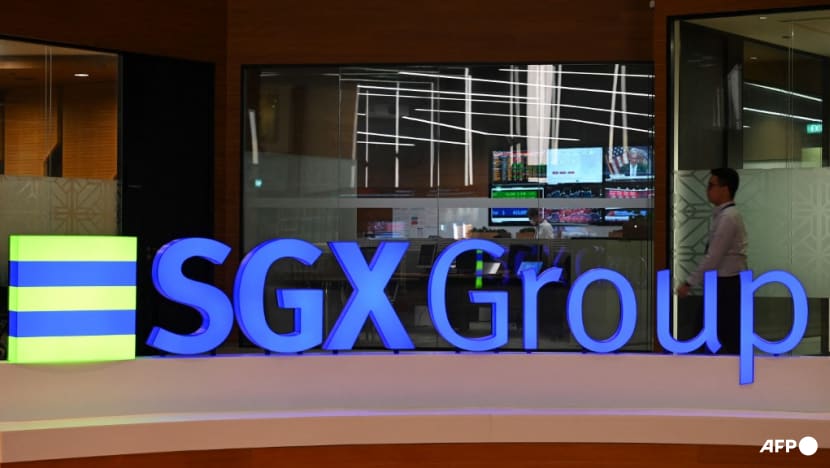 a close up of a sign that says sgx group in front of a glass wall