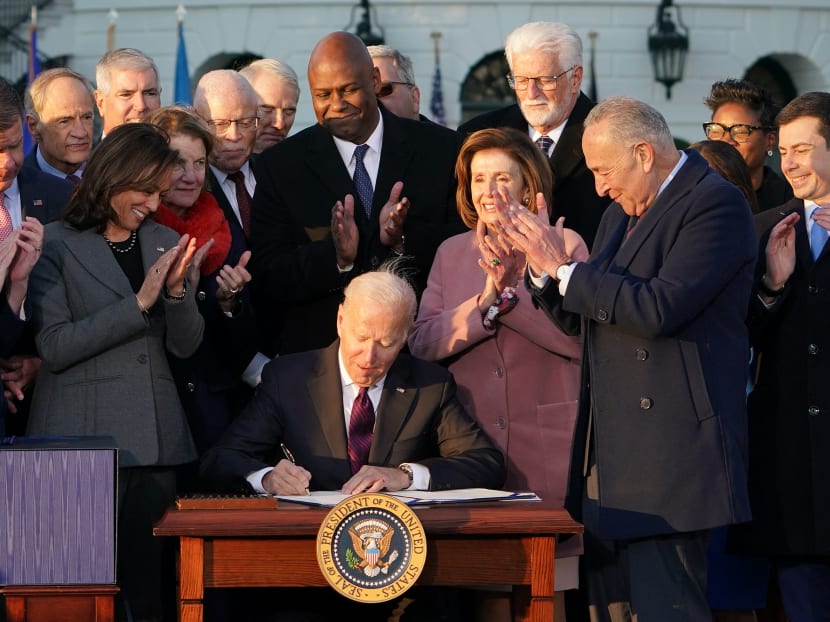 President Joe Biden signs the infrastructure bill on the South Lawn of the White House on Nov 15, 2021 (pictured). The US$1.2 trillion (S$1.6 trillion) package will fix bridges and roads, change out unhealthy lead water pipes, build an electric vehicle charging network, and expand broadband internet.