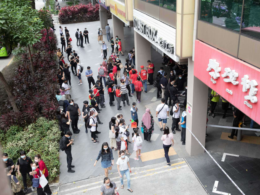 Crowds are seen outside Chinatown Point at about 12pm on March 12, 2021.