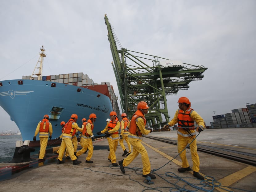 Dock workers tie mooring ropes as the world's largest container ship, the MV Maersk Mc-Kinney Moller, berths during its maiden port of call at a PSA International port terminal in Singapore. Although the port and maritime industry is a critical part of the Singapore economy, it is hardly featured prominently. Photo: Reuters