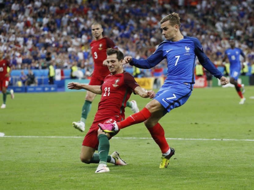 France's Antoine Griezmann in action with Portugal's Cedric. PHOTO: REUTERS