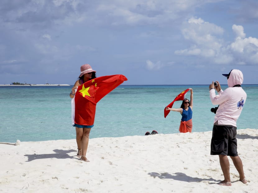 Chinese tourists taking photos with their national flag at Quanfu island, part of the disputed Paracels. Photo: AP