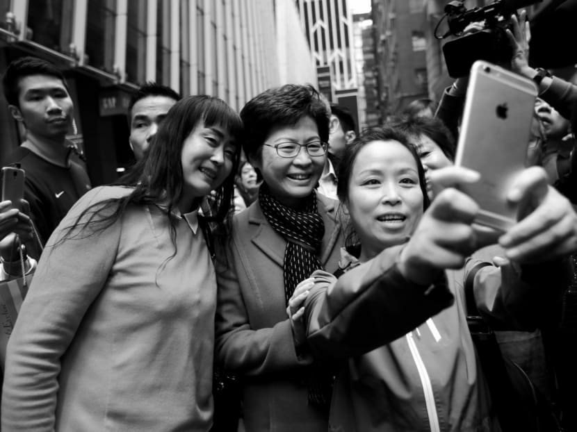 People taking selfies with Ms Carrie Lam, Hong Kong’s next Chief Executive, a day after she was elected. Ms Lam said her focus will be on uniting the people of Hong Kong. Photo: Reuters