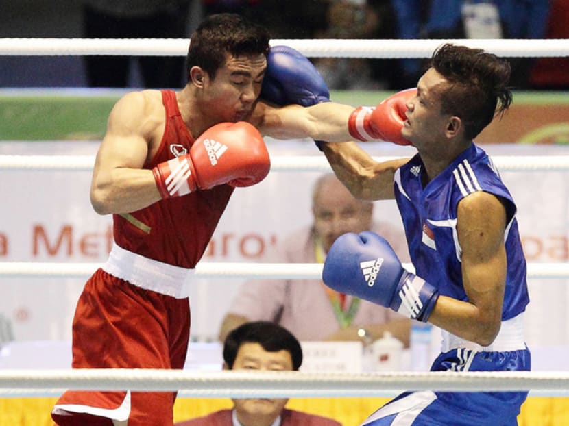 Among the Republic’s boxers who went to Colombo was Myanmar bronze medallist Solihin Nordin (in red), seen here fighting Thailand’s Donchai Thathi during the 2013 SEA Games in Myanmar. 
Photo: Getty Images