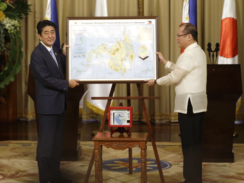 Japanese Prime Minister Shinzo Abe, left, presents Philippine President Benigno Aquino III with a topographical map of the country's third largest island of Mindanao at the conclusion of their joint press statement Saturday July 27, 2013 at Malacanang Palace in Manila, Philippines. Photo: AP