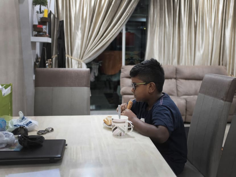 A student, eating his breakfast, before making the long journey across the Causeway to Singapore to attend school on Oct 25, 2017. Photo: Jason Quah/TODAY