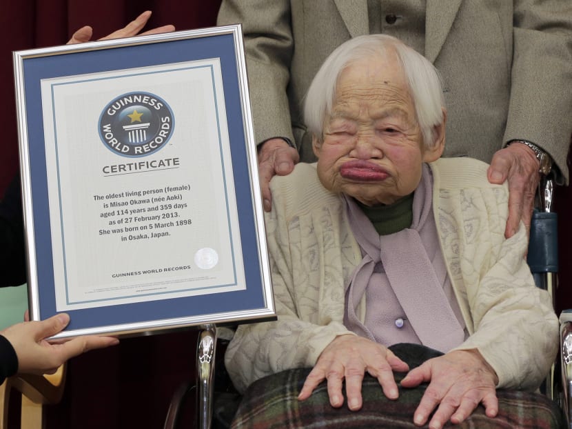 Japan's 114-year-old Misao Okawa, right, poses with the certificate of the world's oldest living woman, which was presented to her by Guinness World Records Japan Country. Photo: AP