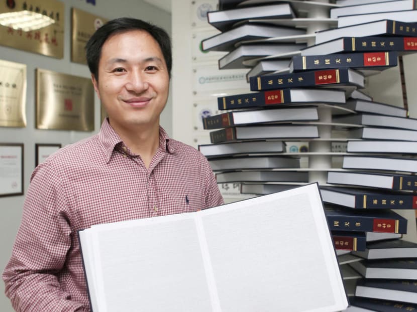 Scientist He Jiankui poses with "The Human Genome", a book he edited, for a photo at his company Direct Genomics in Shenzhen in August, 2018.