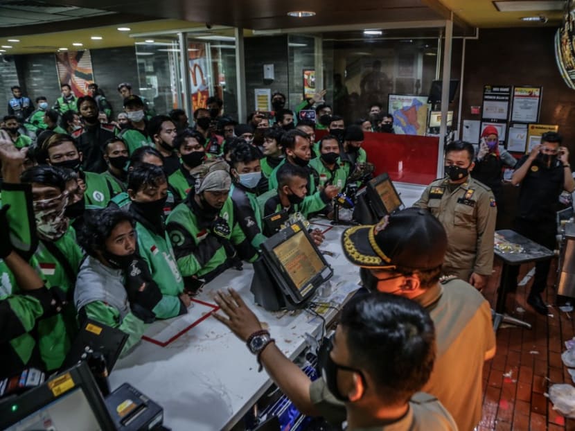 Food delivery riders queue up at a McDonald’s outlet in Bogor on June 9, 2021, to buy the new BTS-meal deal for hungry fans in the K-Pop mad country, causing more than a dozen McDonald's outlets to temporarily shuttered over virus fears.