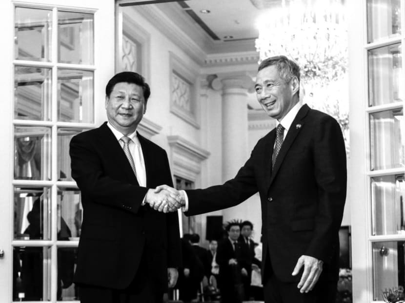 Chinese President Xi Jinping (L) and Singapore Prime Minister Lee Hsien Loong shake hands for the media at the Istana presidential palace in Singapore, November 7, 2015.  REUTERS/Wallace Woon/Pool