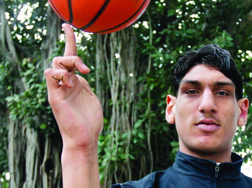 Satnam Singh Bhamara poses with a basketball at Talkatora Stadium in New Delhi, India in 2011. AP file photo
