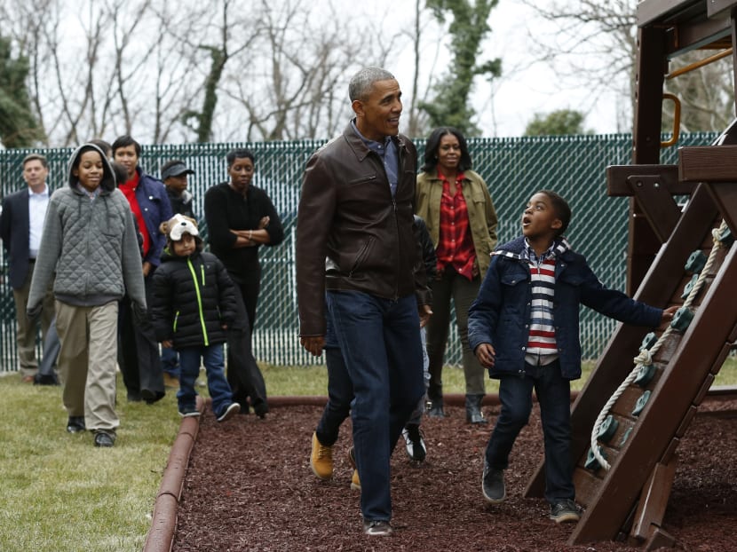 US President Barack Obama and First Lady Michelle Obama playing with children on a swing donated by the first family at the Jobs Have Priority Shelter in Washington on Jan 16, 2017. Photo: AFP