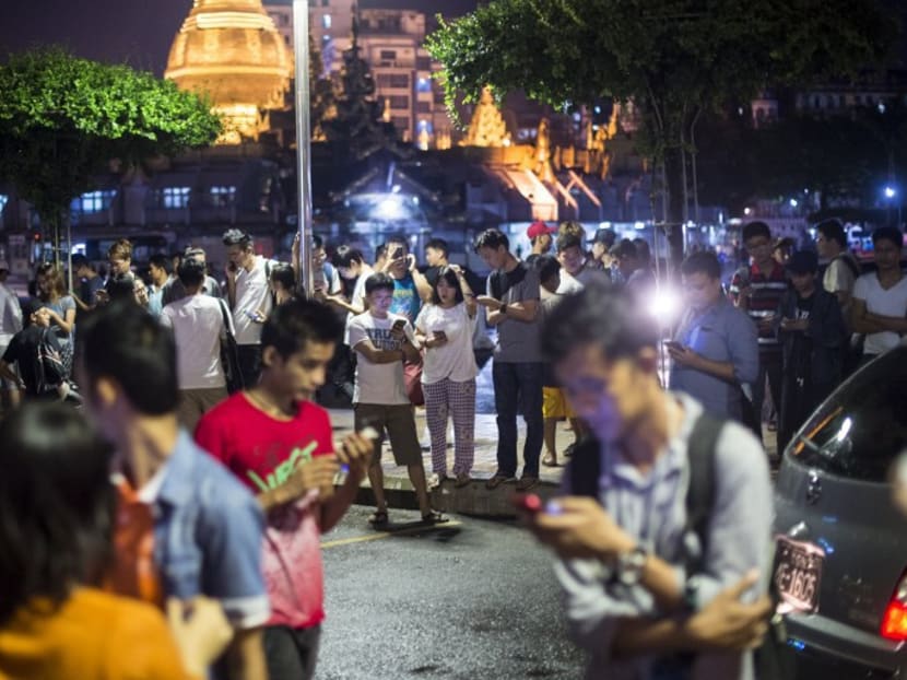 Residents of Yangon gather in the street near the city hall to play Pokemon Go on their smartphones. Photo: AFP