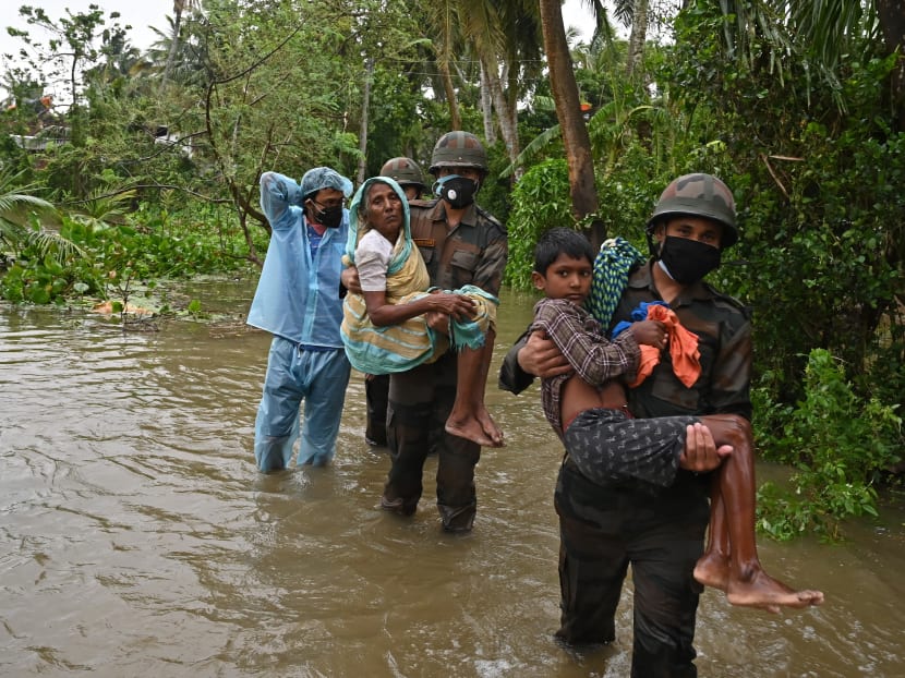 Indian army personnel wades through the flooded village roads carrying people to safety as Cyclone Yaas barrels towards India's eastern coast in the Bay of Bengal in Ramnagar some 180km from Kolkata on May 26, 2021.